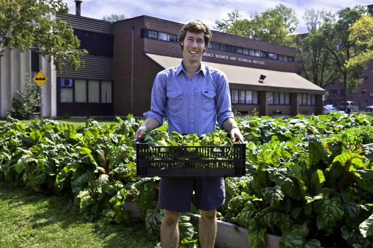 Ian Hepburn-Aley of FoodShare holds produce grown at Toronto's Bendale School Market Garden. Urban farming is gaining momentum in Canada as more people look towards ways urban centres can produce more food on rooftops or backyards now covered with grass. Toronto will host the first-ever Urban Agriculture Summit from Aug. 15 to 18. (Courtesy of Laura Berman, GreenFuse Photography)