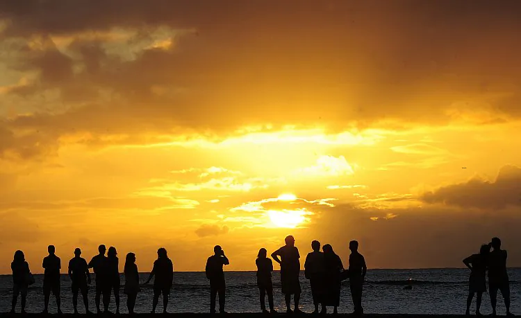 People gather to watch the sunset from Waikiki Beach in Honolulu, Hawaii, Nov. 10, 2011 in this file photo. Hawaii scored the highest rating on a U.S. Wellbeing index and is also America’s favorite state (Emmanuel Dunand/AFP/Getty Images)