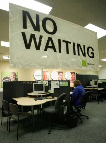 Income tax advisor Jennifer Richards works inside an H&R Block location in Des Plaines, Illinois in this file photo. While the sign in the photo says “No Waiting” a mistake in processing 660,000 forms for educational tax credits means a delay of as many as six weeks for H&R Block customers. (Tim Boyle/Getty Images)