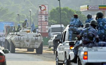 Ivory Coast violence: Bangladeshi U.N. peacekeepers patrolling the Abobo neighborhood are followed by Ivory Coast's national police (R) in Abidjan on Dec. 27. Ivory Coast strongman Laurent Gbagbo saw off another challenge to his rule as a call for a general strike fell flat, and he prepared to facedown an ultimatum from West African leaders. (ISSOUF SANOGO/AFP/Getty Images)