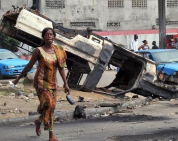 A woman crosses the street in front of a burnt-out United Nations peacekeeper car on Thursday in the Yopougon neighbourhood of Abidjan, home to supporters of Laurent Gbagbo. A mob attacked a UN convoy in Abidjan on December 28, 2010, injuring one peacekeeper with a machete and setting a vehicle alight, the UN said. (Issouf Sanogo/AFP/Getty Images)