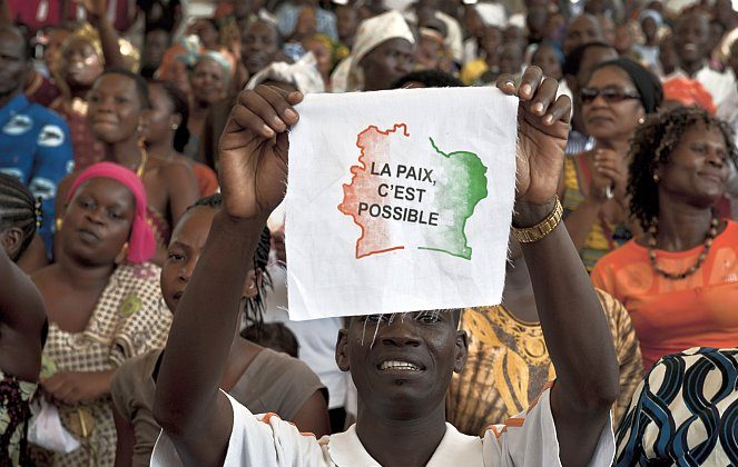 An Ivorian man displays a message on a piece of fabric reading in French "Peace is possible," as 5,000 Ivorians gather on March 27, 2011, at the Culture Palace of Abidjan to pray for peace. The national reconciliation process in Ivory Coast is facing hard times, as the conflict between the camps of President Alassane Ouattara and his predecessor Laurent Gbagbo bubble and threaten to boil over once more. (Jean-Philippe Ksiazek/AFP/Getty Images)
