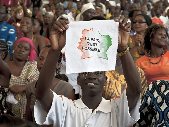 An Ivorian man displays a message on a piece of fabric reading in French "Peace is possible," as 5,000 Ivorians gather on March 27, 2011, at the Culture Palace of Abidjan to pray for peace. The national reconciliation process in Ivory Coast is facing hard times, as the conflict between the camps of President Alassane Ouattara and his predecessor Laurent Gbagbo bubble and threaten to boil over once more. (Jean-Philippe Ksiazek/AFP/Getty Images)