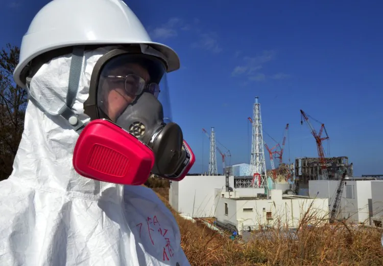 A journalist watches the stricken Fukushima Daiichi nuclear power plant on Feb. 28. Recent studies conclude that the accident was entirely preventable. (Yoshikazu Tsuno/AFP/Getty Images)