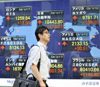 A businessman passes before a share prices board in Tokyo. Beijing purchased a net 457 billion yen (US$5.3 billion) of Japanese government debt in June. (Yoshikazu Tsuno/AFP/Getty Images)