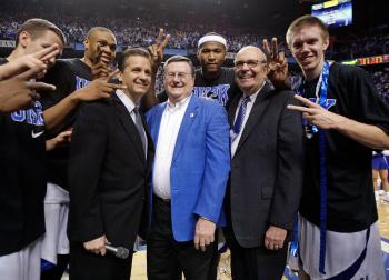 John Calipari (left in suit), Joe Hall (middle), who coached Kentucky to a national championship, and Herky Rupp (right), son of former coach Adolph Rupp, celebrate with current Wildcats players after their 2,000th win on Monday night. (Andy Lyons/Getty Images)