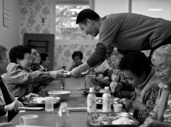 ACT OF SERVICE: A volunteer serves lunch to elderly community housing residents in Pannam. Korean society is aging rapidly, and government policies are struggling to keep up with the pace of change. However, many ordinary Koreans are not prepared to give up on their long tradition of respect and care for the elderly. (Jarrod Hall/The Epoch Times.)