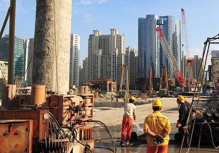 Laborers work at a new property development under construction on the busy Nanjing Road shopping street in Shanghai, Oct. 9, 2011. China has invested heavily in property--about $750 billion in 2010 alone--since it privatised the market in the late 1990s, ending decades of state allocated housing and enabling a growing middle class to own their own homes. A massive stimulus package unveiled in late 2008 to combat the global financial crisis also funnelled a large portion into construction. (Mark Ralston/AFP/Getty Images)