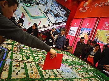Sales people introduce properties to potential buyers at the 2008 Beijing Autumn Real Estate Trade Fair in Beijing, China. (Feng Li/Getty Images)