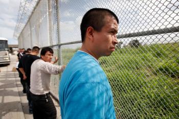 Mario Alberto-Lopez (R) waits to be unshackled by U.S. Immigration and Customs Enforcement (ICE) agents before being led to the Mexican border and released from custody on May 25. (Scott Olson/Getty Images)