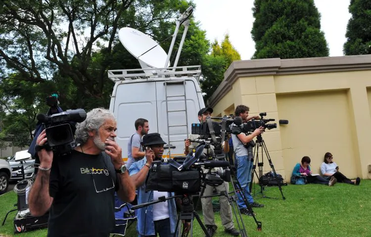 Media stand outside the home of South Africa's former president and Nobel Peace Prize winner in Johannesburg on Feb. 26. Nelson Mandela was discharged from a South African hospital on Sunday after a minor diagnostic procedure. Mandela was admitted on Saturday for an abdominal complaint. (Alexander Joe/AFP/Getty Images)