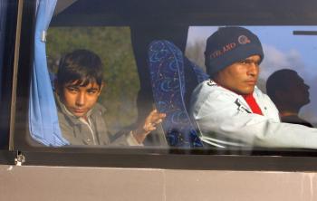 Migrants are transported in coaches by the French police away from a makeshift migrant camp in Calais, France on Sept. 22, 2009. (Oli Scarff/Getty Images)