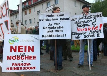 Protesters hold signs while demonstrating against the nearby Khadija Mosque shortly before its official opening ceremony on Oct. 16, 2008 in Berlin, Germany. The Khadija Mosque was the first mosque to open in east Berlin and provoked protests from nearby residents, who claim they fear an Islamization of their neighborhood. (Sean Gallup/Getty Images) Protesters hold signs while demonstrating against the nearby Khadija Mosque shortly before its official opening ceremony on Oct. 16, 2008 in Berlin, Germany. The Khadija Mosque was the first mosque to open in east Berlin and provoked protests from nearby residents, who claim they fear an Islamization of their neighborhood. (Sean Gallup/Getty Images)