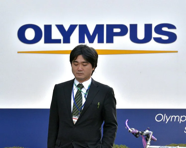 A businessman walks past a showroom of the troubled Japanese optical company Olympus in Tokyo on Jan. 10. Scandal-hit Olympus said it was suing 19 current and former executives for a combined US$215 million in damages relating to a massive investment cover-up. (Yoshikazu Tsuno/AFP/Getty Images)