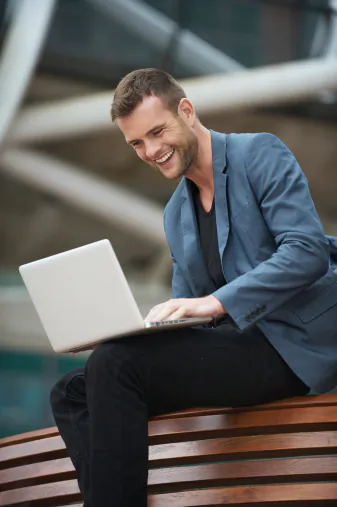 A young man enjoys an online chat with friends. A recent survey of over 12,000 people in 25 countries reports that 20 percent of people feel more outgoing while online. (m-imagephotography/Photos.com)