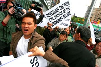 A man attacks Falun Gong practitioners in May, 2008 in Flushing, Queens. The attacks against Falun Gong practitioners carried on for several months. (The Epoch Times) A man attacks Falun Gong practitioners in May, 2008 in Flushing, Queens. The attacks against Falun Gong practitioners carried on for several months. (The Epoch Times)