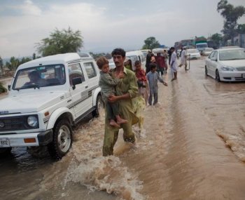 Local residents travel down a flood affected road on August 1,  in Nowshera, Pakistan. Rescue workers and troops in northwest Pakistan struggled to reach thousands of people affected by the country's worst floods since 1929.   (Daniel Berehulak/Getty Images)