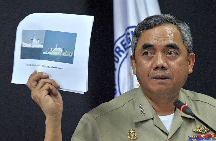 Philippine Navy Vice Adm. Alexander Pama shows a picture of the two Chinese maritime vessels that blocked a Philippine warship from arresting Chinese fishermen on April 11. (Noel Celis/AFP/Getty Images)