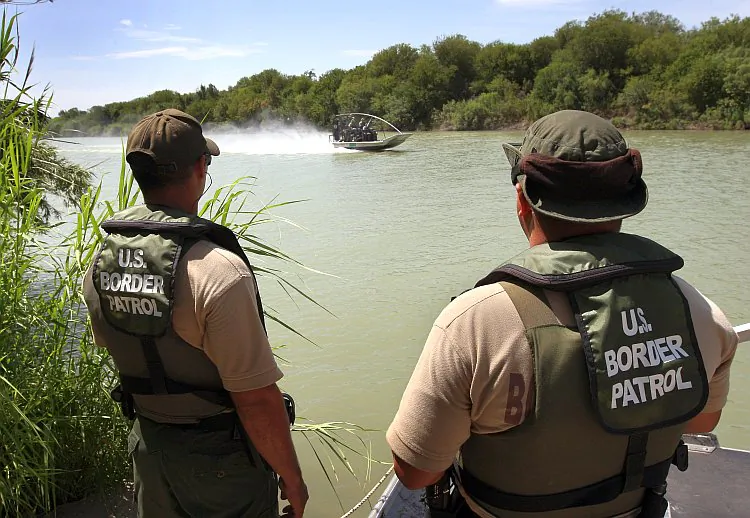 U.S. Border Patrol agents patrol the Rio Grande crossing into the United States in this file photo from Aug. 7, 2008, near Laredo, Texas. The plant to their left appears to be Carrizo cane. (John Moore/Getty Images)