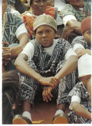 The new king of the Fondonera clan, Nteubou Etienne Djeudo Jr.,  among the king’s children mourning in a sitting posture. (The Epoch Times)