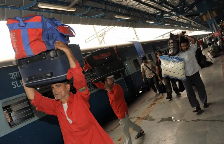 Indian porters and passengers carry luggage at the New Delhi railway station. Railway porters operate in India under licenses issued by the authorities. The profession is largely dominated by men. (Manan Vatsyayana/AFP/Getty Images)