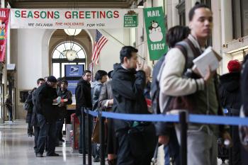 People wait in line to mail packages and letters at the James A. Farley Post Office building on the busiest day of the year at the post office, Dec. 14, 2009, in New York City. (Mario Tama/Getty Images)