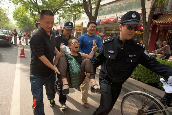 A protester is removed by police outside the Chaoyang Hospital