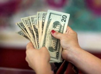 A woman holds money in an apparel store in Miami, Florida. The most recent U.S. economic recession officially ended in June 2009. (Joe Raedle/Getty Images)