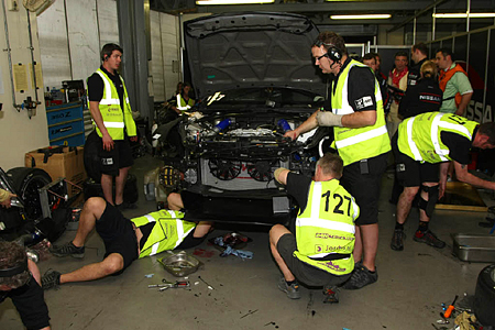 The mechanics work to repair the #127 GT Academy RJN Nissan 370z. (24hDubai.com)