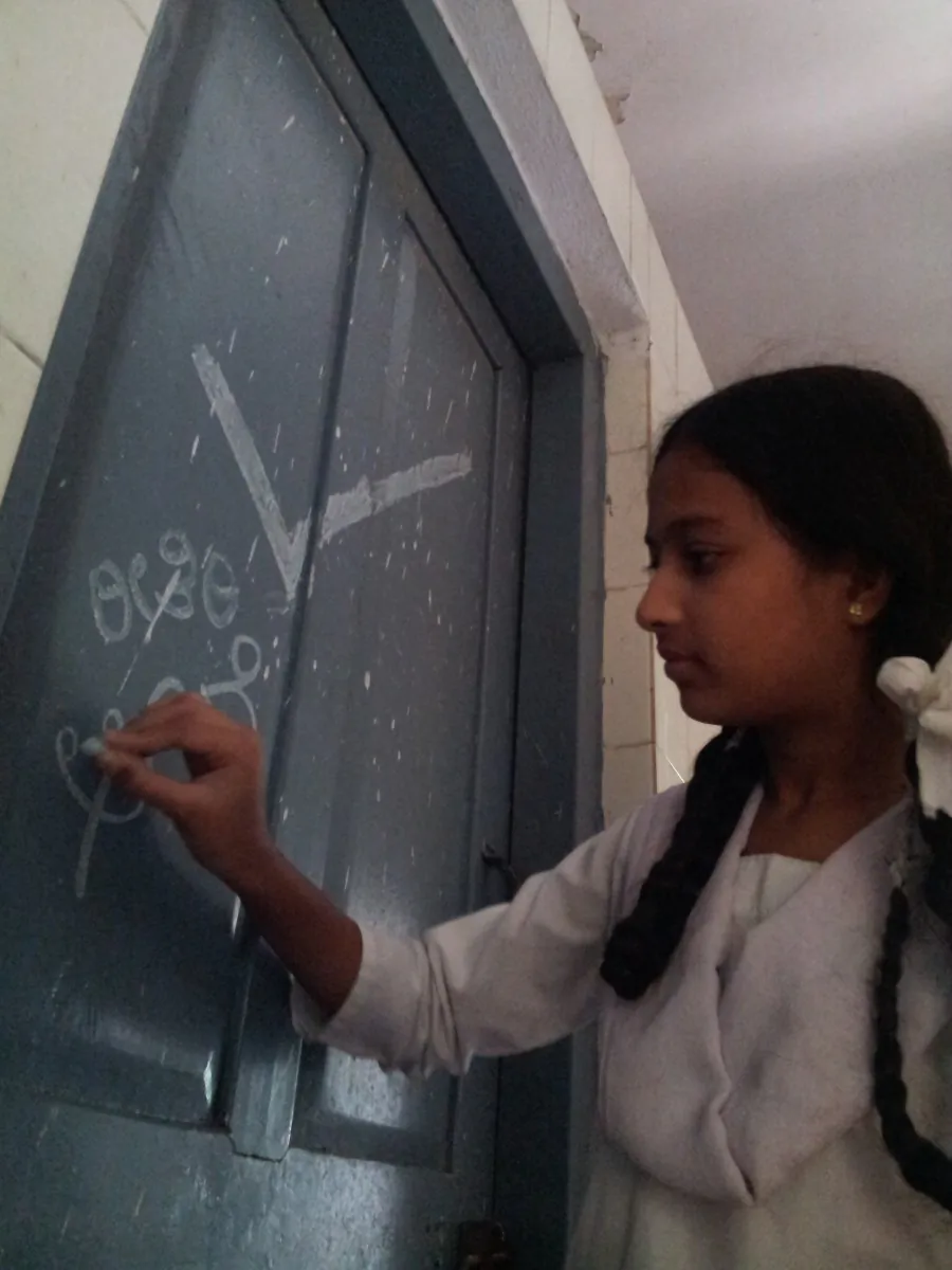 A student fixing a dry toilet that operates without water, and uses oil to eliminate the odor at Saarakki Government High School, Bangalore.(Reap Benefit)