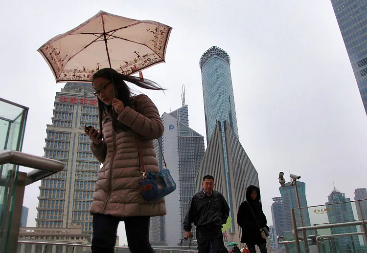Pedestrians walk through the Lujiazui Financial District in Shanghai, on Jan. 15. According to a recent Barclays Capital study, the skyscraper-building boom in China could be a sign of an inevitable collapse of China's economy. (Qilai Shen/Bloomberg via Getty Images)