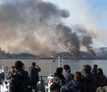 This picture taken on Nov. 23, 2010, by a South Korean tourist shows huge plumes of smoke rising from South Korea's Yeonpyeong Island due to an artillery attack from North Korea. (STR/AFP/Getty Images)