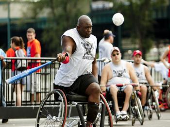 A player for the Columbus Pioneers wheelchair softball team swings at the 34th Annual National Wheelchair Softball Tournament outside Citi Field, in Queens, on Thursday. (Henry Lam/The Epoch Times)