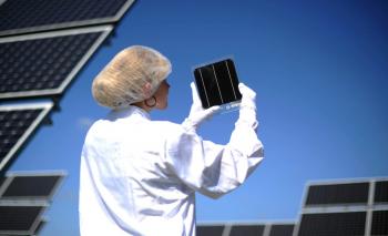 An employee of German company Bosch Solar Energy, holds a photovoltaic cell at the company's new plant in Arndstadt, eastern Germany, on August 20, 2010. German companies are increasing their production capacity of renewable energy generators. (Johannes Eisele/AFP/Getty Images)