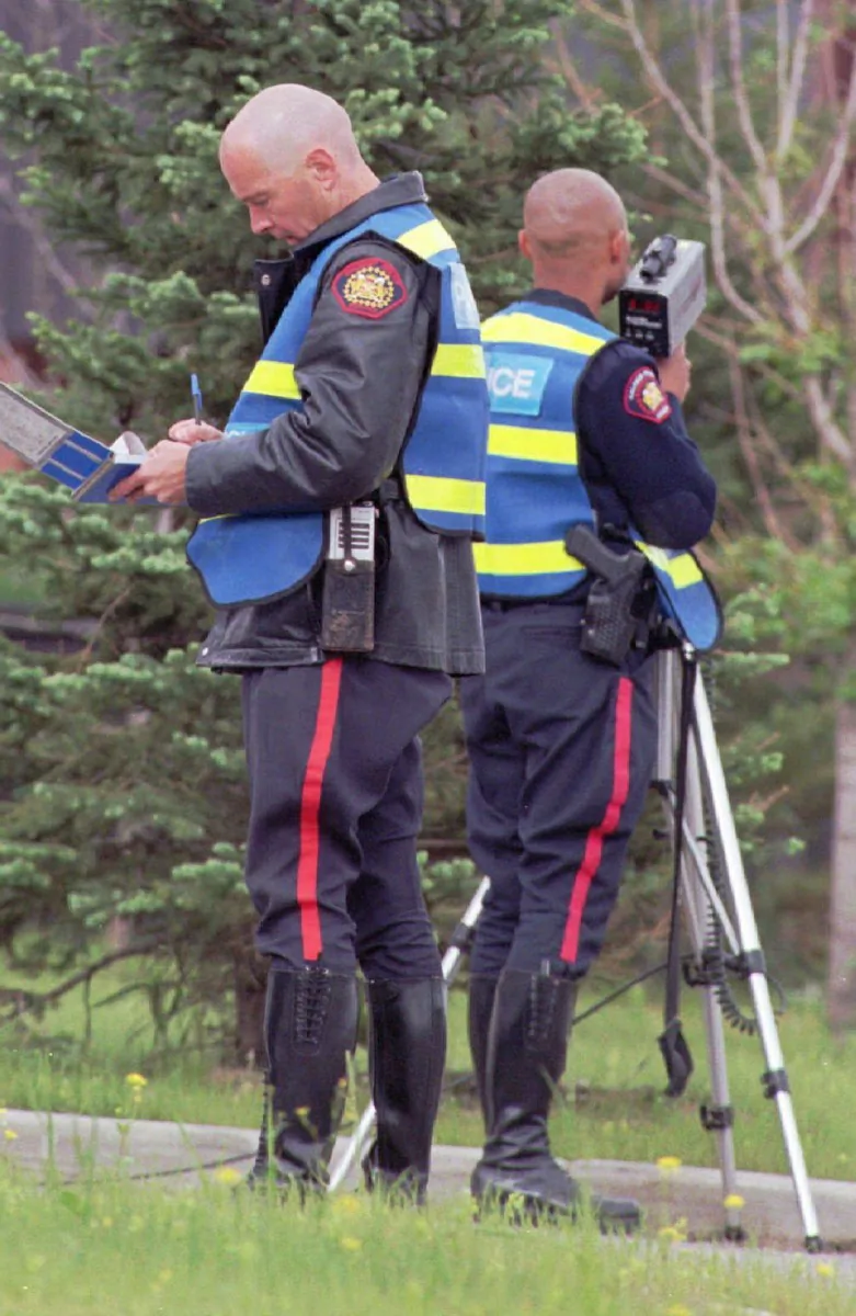 A Calgary police officer writes a speeding ticket in this file photo. Police in Edmonton and Calgary want the right to seize the vehicles of chronic, excessive speeders. (The Canadian Press/Dave Buston)