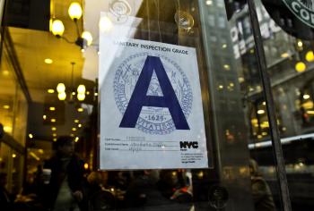 MAKING THE GRADE: A Starbucks coffee shop proudly displays their health inspection grade. Of the restaurants the City has so far graded, 57.2 percent have received an A grade.  (Phoebe Zheng/The Epoch Times)