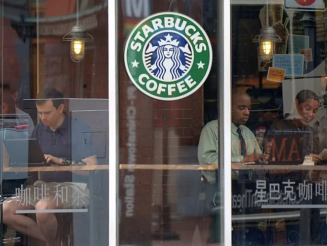 People use their laptop computers at a Starbucks in Washington, D.C., on May 9. Starbucks stock price has been volatile, and according to some analysts, its growth strategy has hit a snag. (Jewel Samad/AFP/GettyImages)