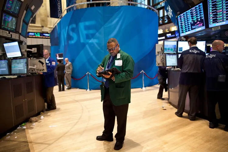 A trader works on the floor of the New York Stock Exchange on March 26. The market soared to a 12-month high after comments made by Ben Bernanke regarding the economy. (Andrew Burton/Getty Images)
