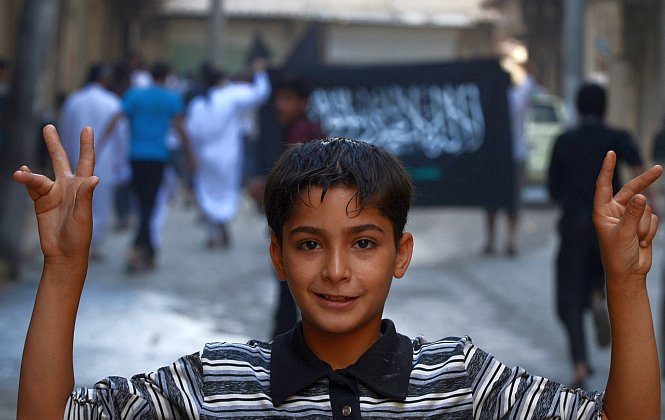 A Syrian boy flashes the V-sign during an anti-regime demonstration in the northern city of Aleppo on Oct. 19, 2012. (Tauseef Mustafa/AFP/Getty Images)