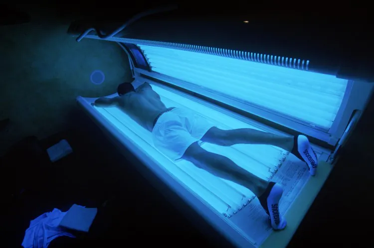 A young man lies in a tanning bed. On Tuesday, Oakville, Ontario, banned tanning bed use by teens due to cancer concerns. (Donald Miralle/Getty Images)