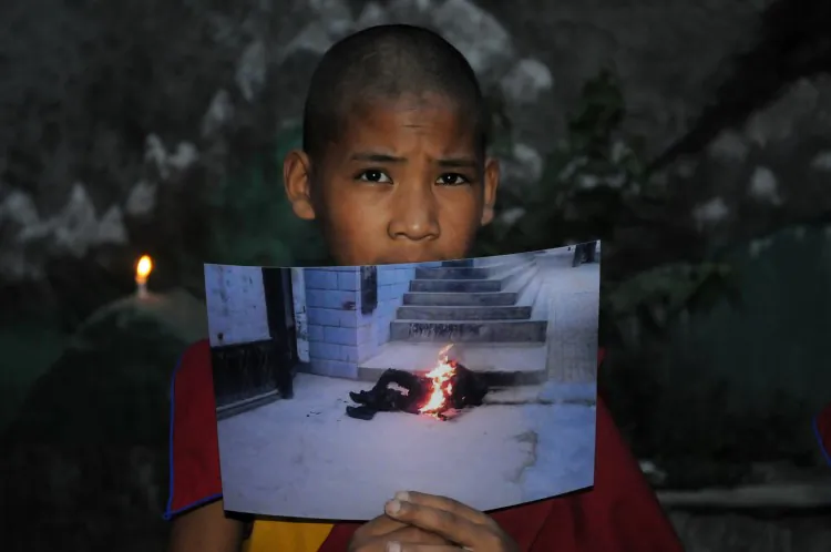 An exiled Tibetan monk holds a picture of self-immolation on June 15 2012. Yonten Gyatso, a prominent Tibetan monk, received a seven-year jail sentence in China for spreading information about immolations in Tibetan regions. (Strdel/AFP/GettyImages)