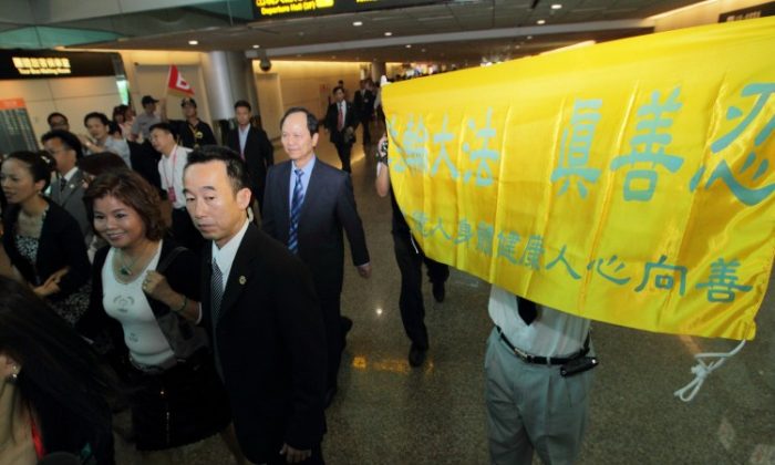 Guangdong governor Huang Huahua on a state visit to Taiwan is met by Falun Gong practitioners holding up banners saying, "Falun Dafa -Truth-Compassion-Forbearance" at Taoyuan Airport, Aug. 16, 2010 (minghui.org)