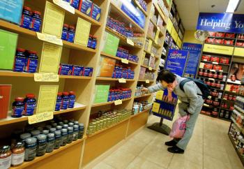 A client consults vitamin supplements at a GNC Vitamin Shop in New York. A new medical report shows a possible link between vitamin B6 intake and a lower chance of developing lung cancer. (Chris Hondros / Getty Images)