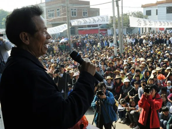 Villagers listen to a speech by village leader Lin Zuluan (L) at a rally after he reached an agreement with Zhu Mingguo, vice secretary of the CCP Committee of Guangdong Province, on Dec. 21, 2011. (Mark Ralston/AFP/Getty Images)