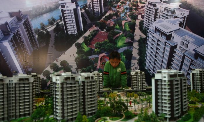 A boy looks at building models in a housing exhibition on Nov. 29, 2008 in Wenzhou of Zhejiang Province, China. Real estate prices have dropped precipitously in the city recently. (China Photos/Getty Images)