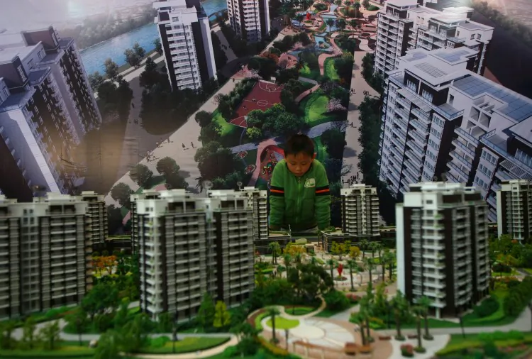 A boy looks at building models in a housing exhibition on Nov. 29, 2008 in Wenzhou of Zhejiang Province, China. Real estate prices have dropped precipitously in the city recently. (China Photos/Getty Images)