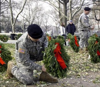 A soldier places a wreath in Battery Park in lower Manhattan on Saturday. December 11 is Wreaths Across America Day, a day to remember those that have died in service to the U.S. (Phoebe Zheng/The Epoch Times)