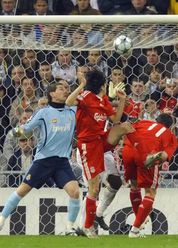 SURPRISE HEADER: Liverpool’s Yossi Benayoun (center) sends a header high over a helpless Iker Casillas in the Real Madrid goal. (Philippe Desmazes/AFP/Getty Images)