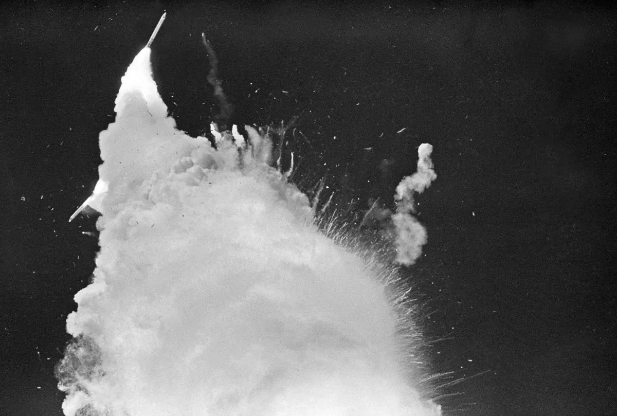 A solid fuel rocket booster disappears behind the contrail of the explosion of the space shuttle Challenger January 28, 1986 over Kennedy Space Center as debris from the orbiter begins to fall to earth. (Bob Pearson/AFP/Getty Images)