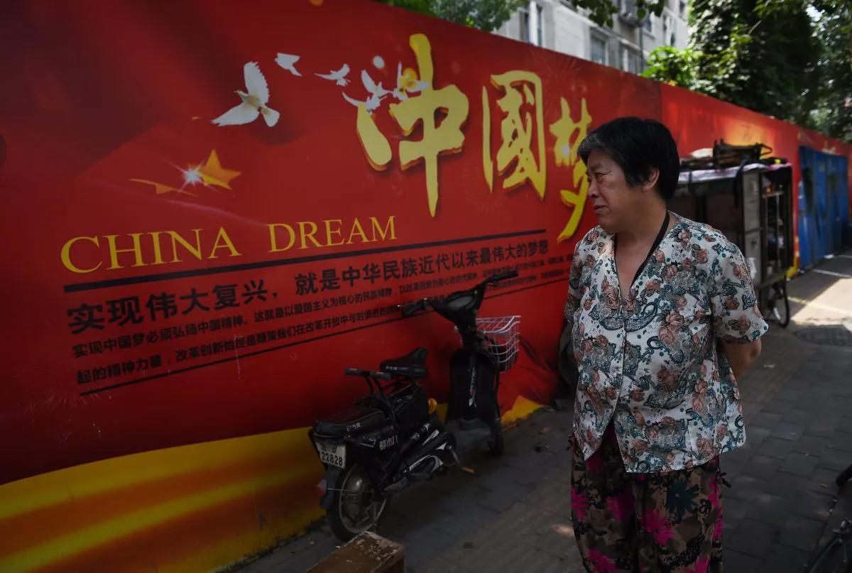 A woman looks at a banner about the "China Dream", Chinese President Xi Jinping's vision for China's future, in Beijing on July 7, 2015. (Greg Baker/AFP/Getty Images)